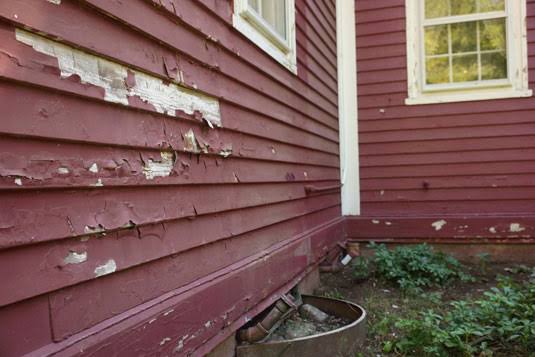 Old wood siding with badly peeling and faded paint